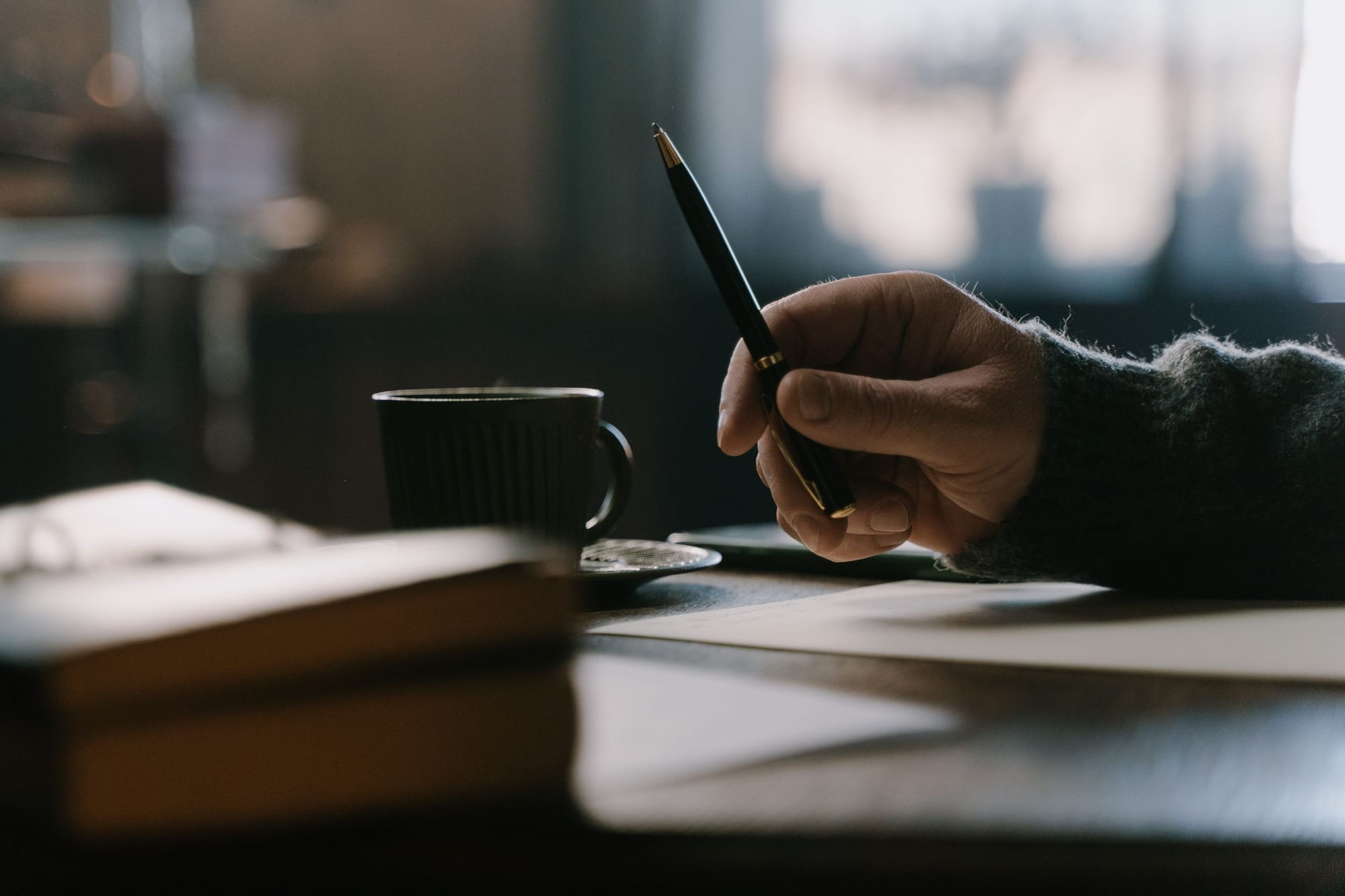 Close-up of a person's hands writing a heartfelt personal letter by hand